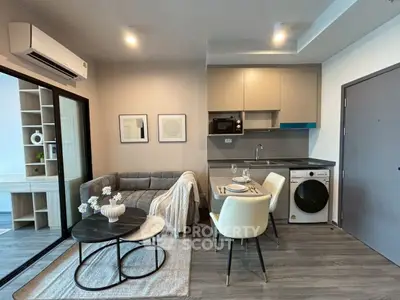 Modern living room with cozy seating and compact kitchen area