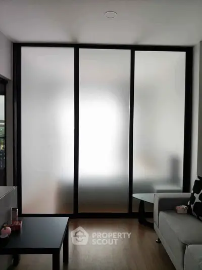 Modern living room with frosted glass partition and sleek furniture
