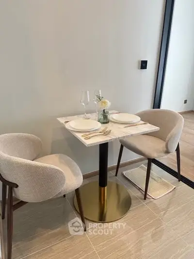 Modern dining nook with elegant table setting and plush chairs in a stylish apartment.