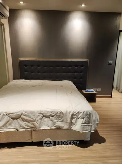 Modern bedroom with elegant headboard and wooden flooring