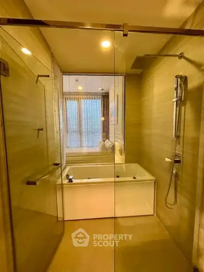 Luxurious bathroom with glass shower and modern bathtub in elegant apartment.