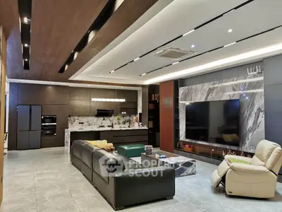Luxurious modern living room with open kitchen, sleek furniture, and large TV for ultimate comfort and style.