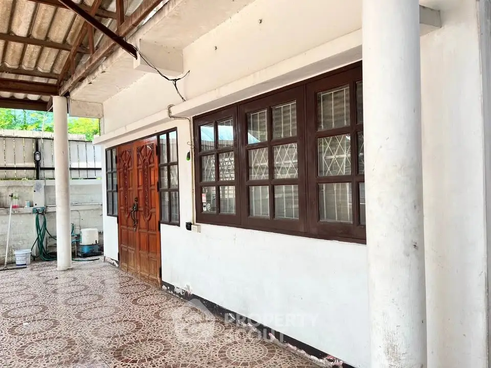 Charming exterior with tiled patio and wooden door, perfect for outdoor relaxation.