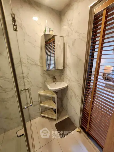Modern bathroom with marble walls and compact sink design