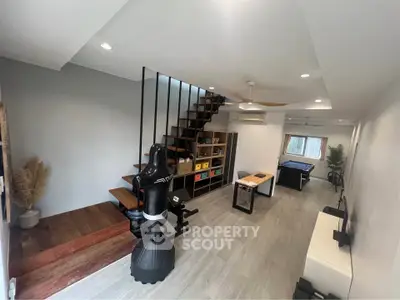 Modern living room with stylish staircase and home gym equipment
