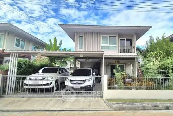 Charming two-story house with carport and lush greenery in a serene neighborhood.
