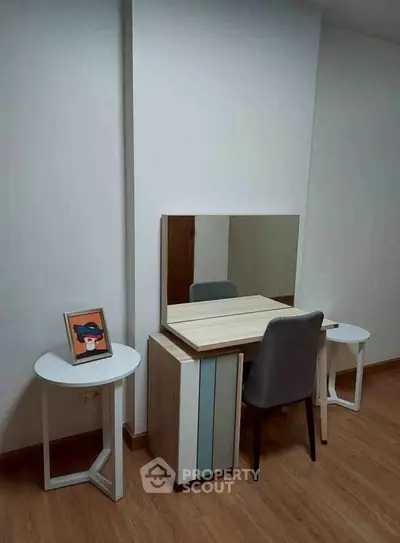 Modern study area with sleek desk, chair, and decorative elements in a minimalist room.