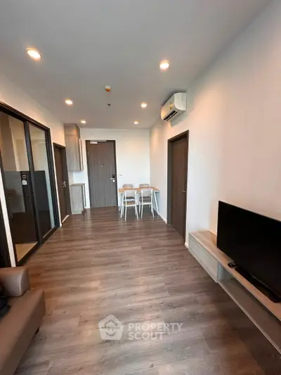 Modern living room with sleek wooden flooring and minimalist furniture design.