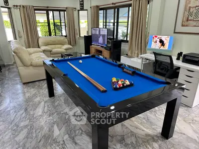 Spacious living room with pool table and entertainment setup, perfect for leisure and relaxation.
