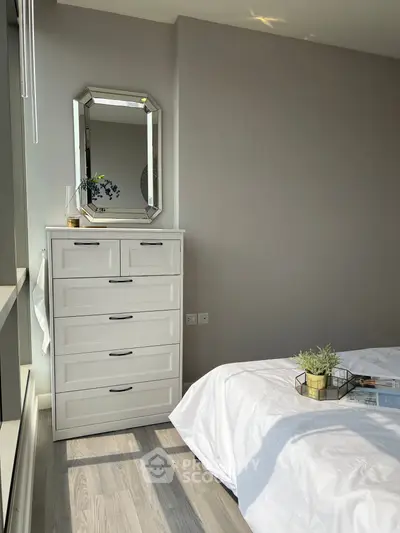 Bright and modern bedroom with elegant white dresser and stylish decor