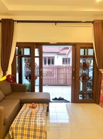 Charming living room with cozy sofa and open view to patio, perfect for relaxation and entertaining.