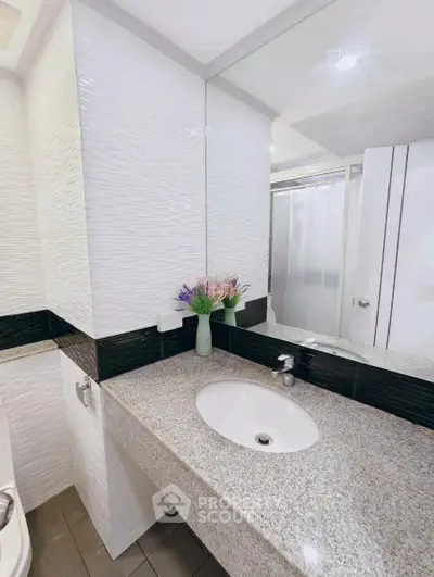 Modern bathroom with sleek granite countertop and elegant floral decor