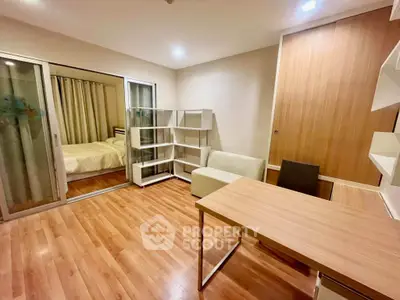 Modern apartment with open layout, featuring a cozy living area and adjacent bedroom.