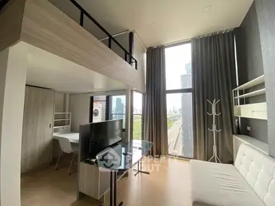 Modern loft-style living room with high ceilings and large windows offering city views.