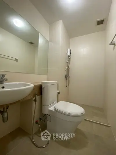 Modern bathroom with sleek fixtures and spacious shower area in a contemporary apartment.