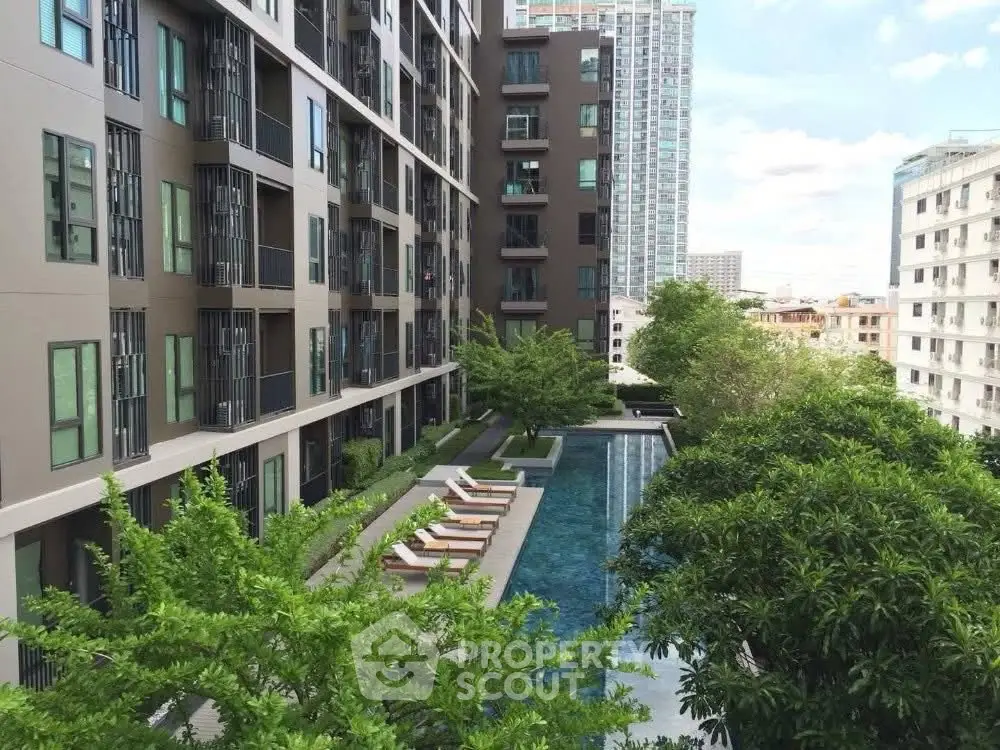 Modern condominium with pool and lush greenery in urban setting