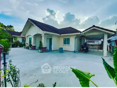 Charming single-story home with spacious driveway and lush greenery