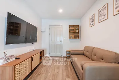 Cozy living room with modern decor, wall-mounted TV, and comfortable sofa in a stylish apartment.