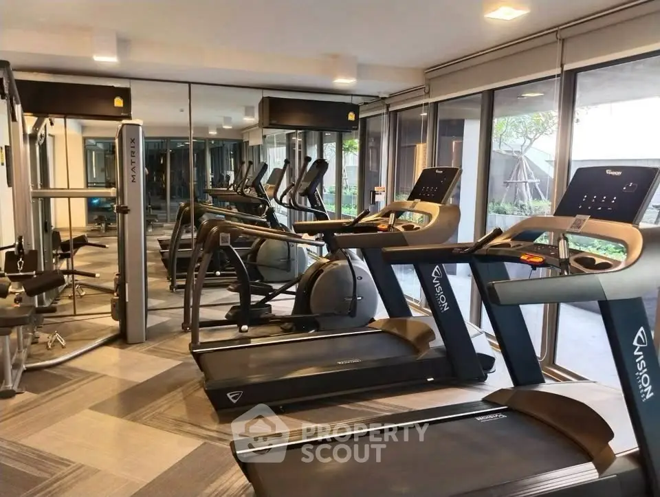 Modern gym with state-of-the-art fitness equipment and mirrored walls in a luxury apartment complex.