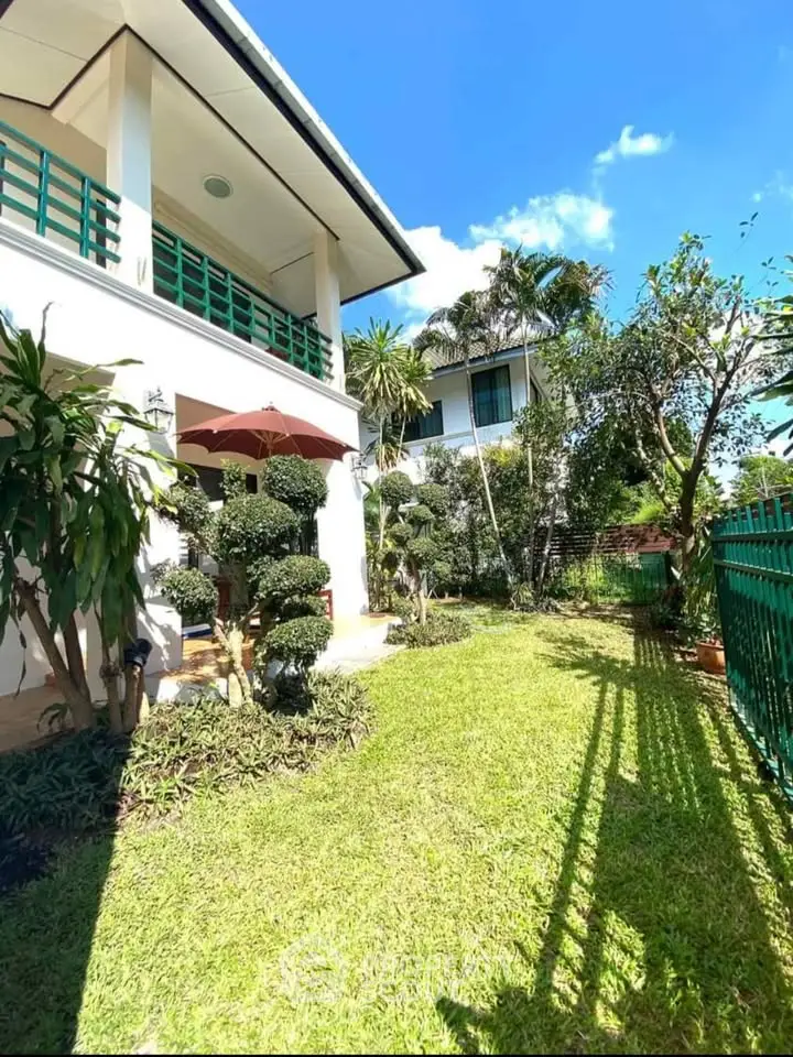 Charming garden view of a modern house with lush greenery and bright blue sky.
