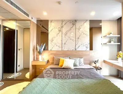 Luxurious modern bedroom with elegant decor and marble accent wall.