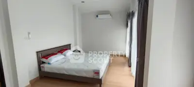Spacious bedroom with natural light and modern air conditioning unit.