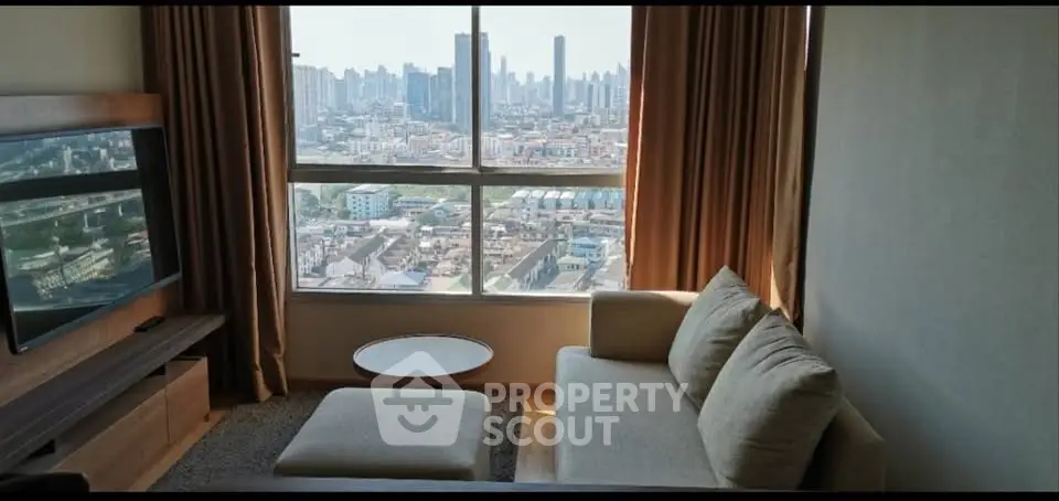 Spacious living room with stunning city view from large window, featuring cozy sofa and modern TV setup.