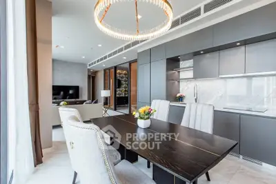 Luxurious modern living room with open kitchen and elegant dining area, featuring chic lighting and stylish decor.