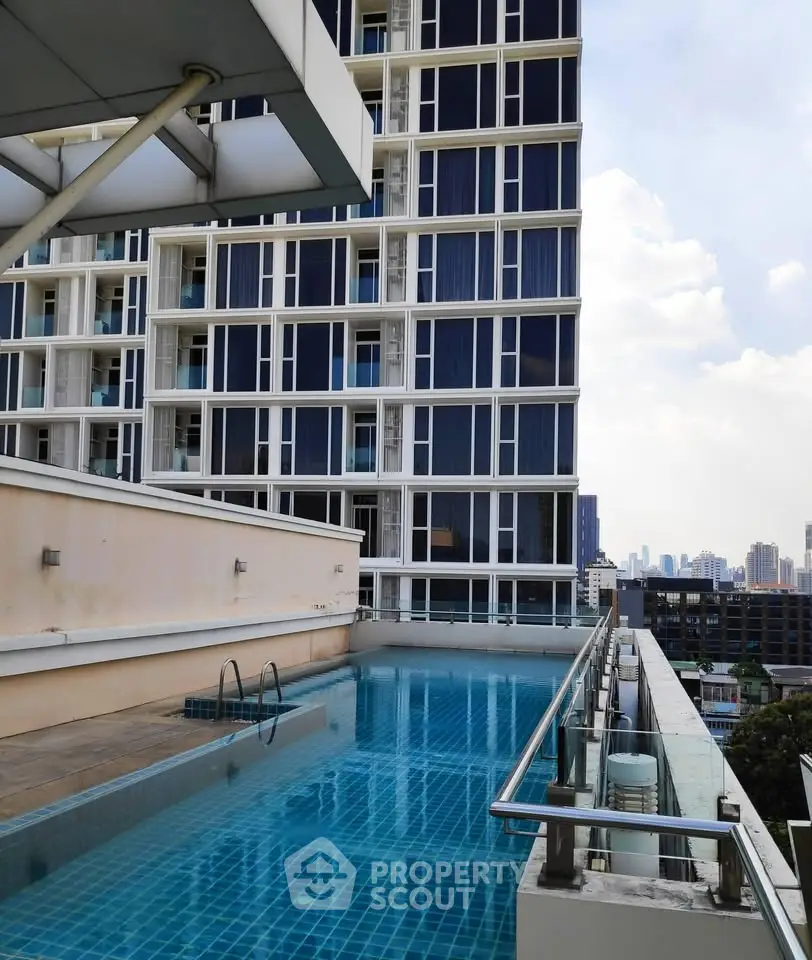 Modern high-rise building with rooftop pool offering stunning city views.