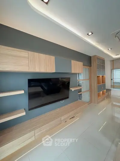Modern living room with sleek wooden entertainment unit and large TV