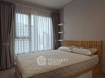 Modern bedroom with large window and elegant curtains in a high-rise apartment.