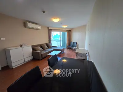 Spacious living room with modern furniture and large windows offering natural light and city views.