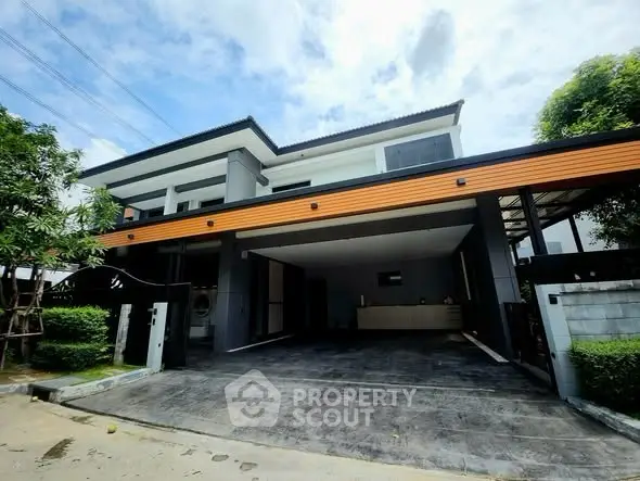 Modern two-story house with spacious driveway and sleek architectural design.