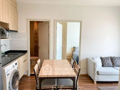 Modern apartment interior with kitchen, dining area, and cozy living room.