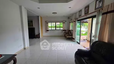 Spacious living room with large windows and garden view, perfect for family gatherings.