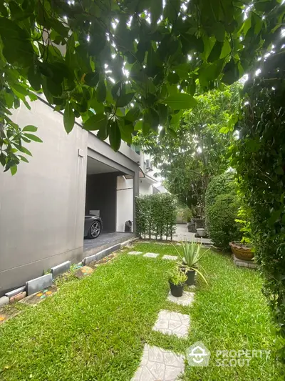 Charming garden view with lush greenery and modern garage in serene residential area.