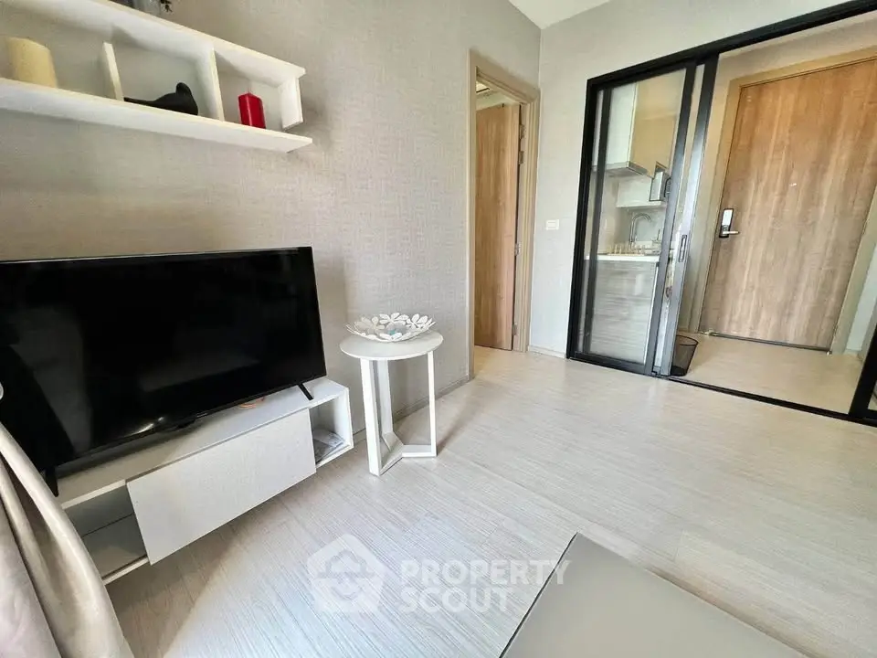 Modern living room with sleek TV setup and stylish decor in a contemporary apartment.