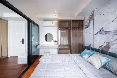 Luxurious bedroom with elegant marble accent wall and spacious walk-in closet