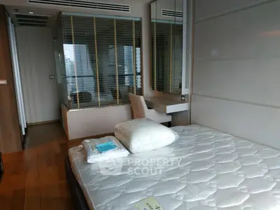 Modern bedroom with large window and wooden flooring in luxury apartment