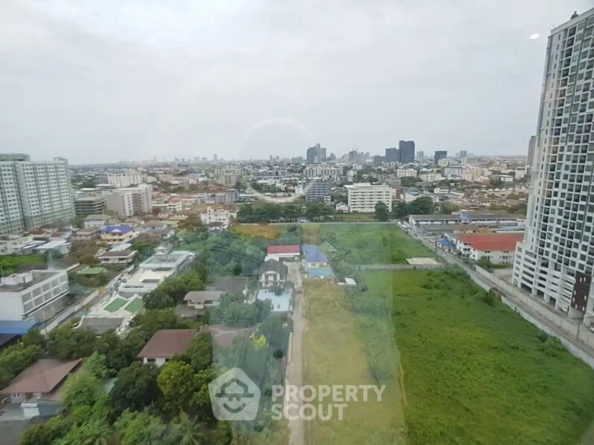 Stunning cityscape view from high-rise apartment window showcasing urban skyline and greenery.