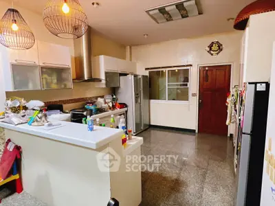 Spacious kitchen with modern appliances and open layout, featuring sleek countertops and ample storage space.