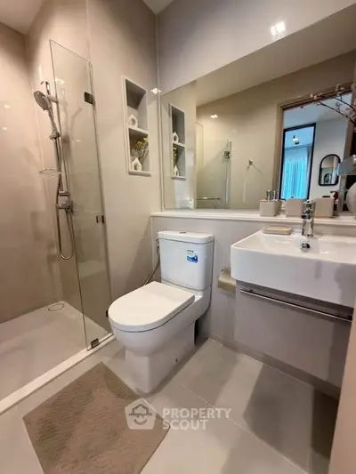 Modern bathroom with glass shower and sleek fixtures in a contemporary apartment.