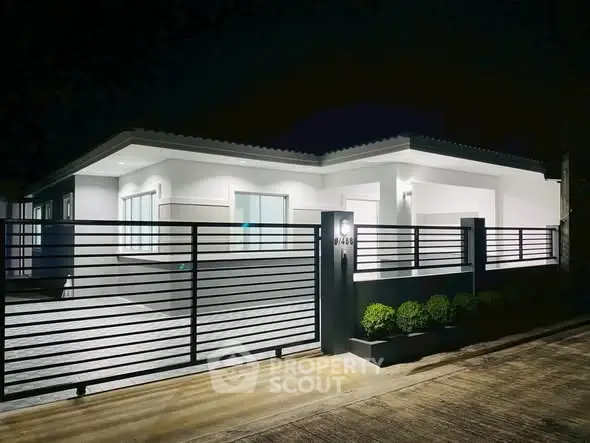 Modern single-story house with sleek design and illuminated exterior at night.