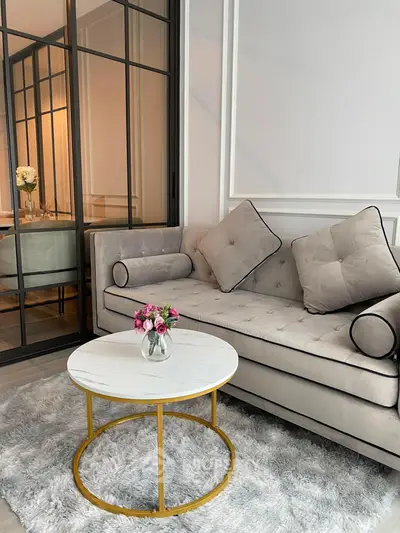 Elegant living room with plush sofa and chic round coffee table on a soft rug.