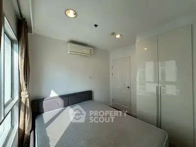Bright bedroom with large window and modern air conditioning unit