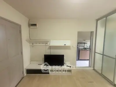 Minimalist living room with TV and open kitchen view