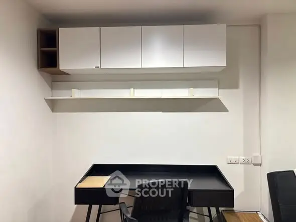 Modern study area with sleek desk and wall-mounted storage cabinets