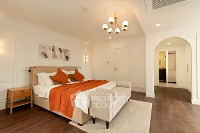 Luxurious bedroom with elegant decor and warm lighting, featuring a plush bed and stylish furnishings.