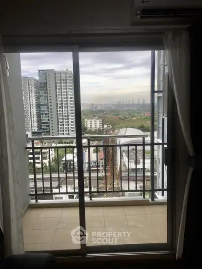 Stunning balcony view from high-rise apartment overlooking cityscape and distant horizon.