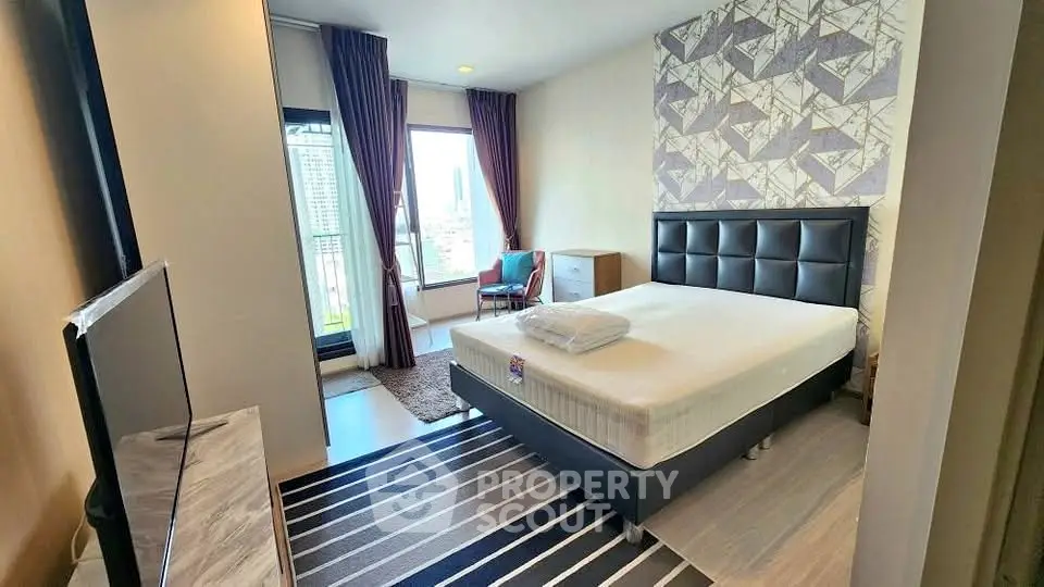 Modern bedroom with stylish decor and city view, featuring a comfortable bed and elegant furnishings.